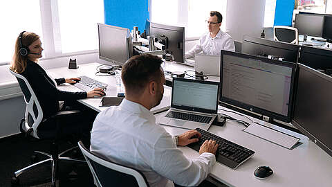 Mitarbeitende von OCTO IT sitzen am Arbeitsplatz
