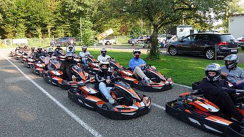 Gruppe von Mitarbeitenden beim Kartfahren
