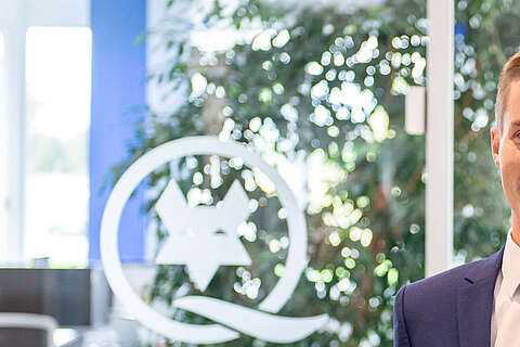 Auszubildender Kaufmann für E-Commerce mit einem Laptop in der Hand