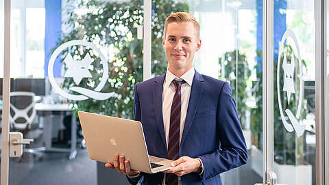 Ausbildung zum Kaufmann im E-Commerce (m/w/d) Auszubildender Kaufmann für E-Commerce mit einem Laptop in der Hand
