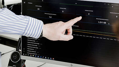 Consulting beim Q-FOX® Person zeigt auf ein Dashboard mit verschiedenen Kennzahlen