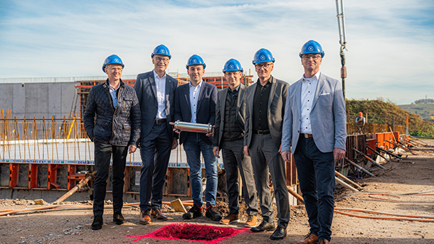 6 Männer mit Anzug und blauen Bauhelmen auf der Baustelle des Rechenzentrums in Lahr