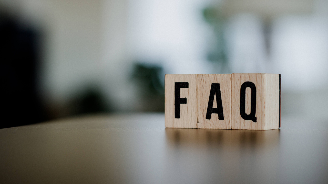 Holzwürfel mit den Buchstaben FAQ auf einem Tisch