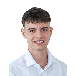 Ein junger Mensch mit kurzen braunen Haaren, der ein weißes Hemd mit Kragen trägt, lächelt vor einem schlichten weißen Hintergrund in die Kamera.